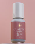 Bottle of Clarity pro adhesive 1.0 on a pink background
