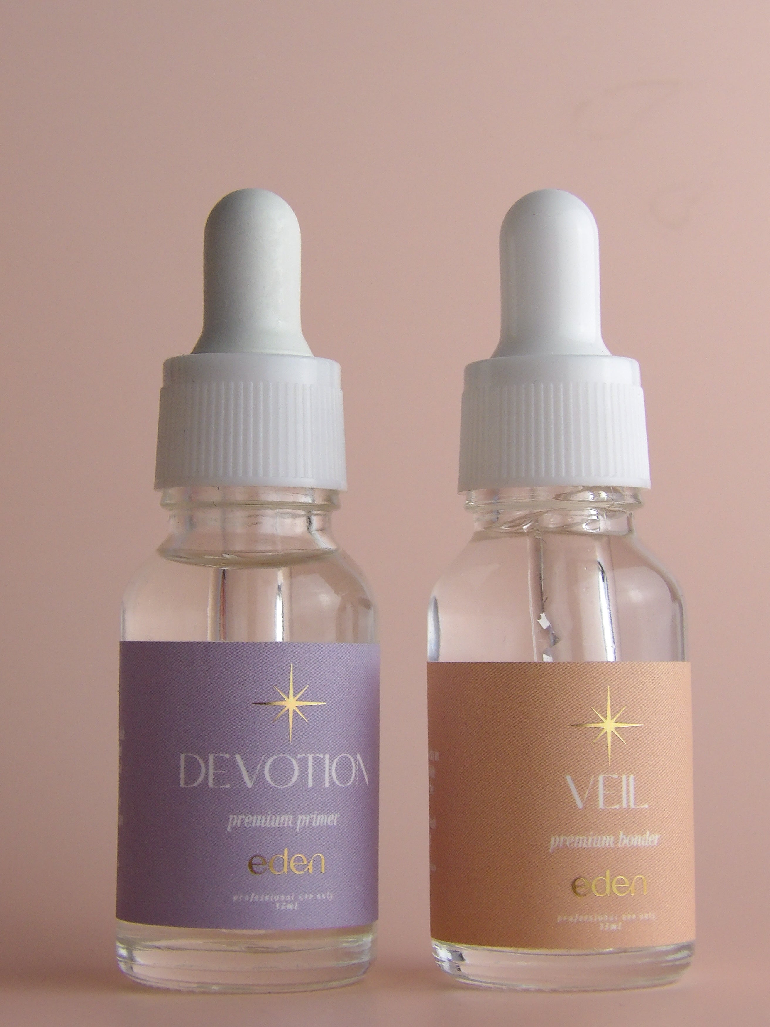 Two bottles of 'Devotion' and 'Veil' with droppers on a beige background