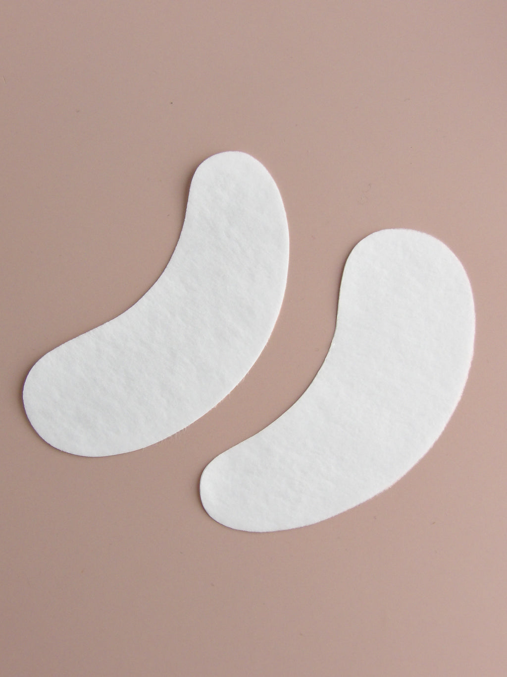 Two white eye patches on a beige background