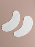 Two white eye patches on a beige background