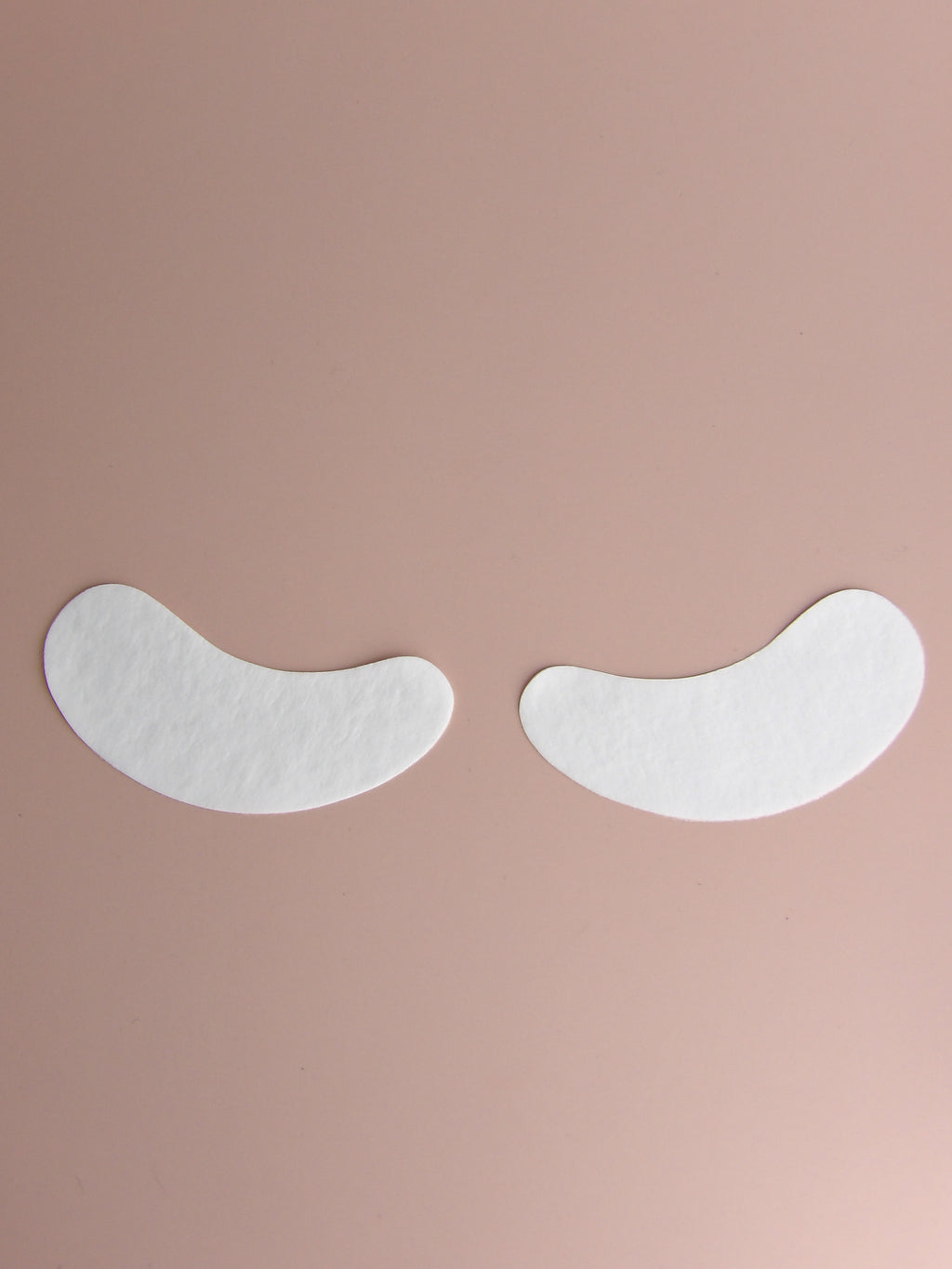 Two white eye patches on a beige background