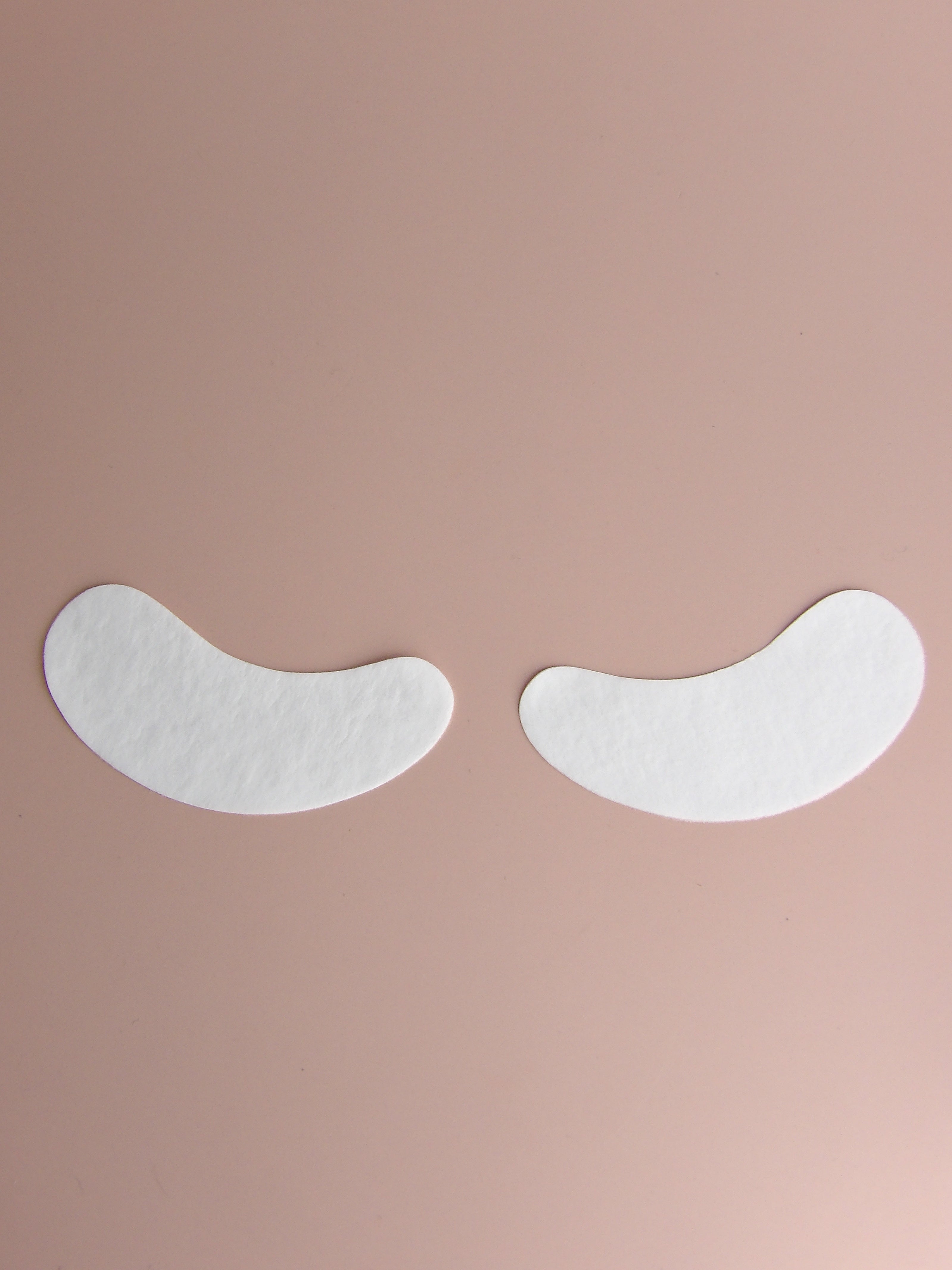 Two white eye patches on a beige background