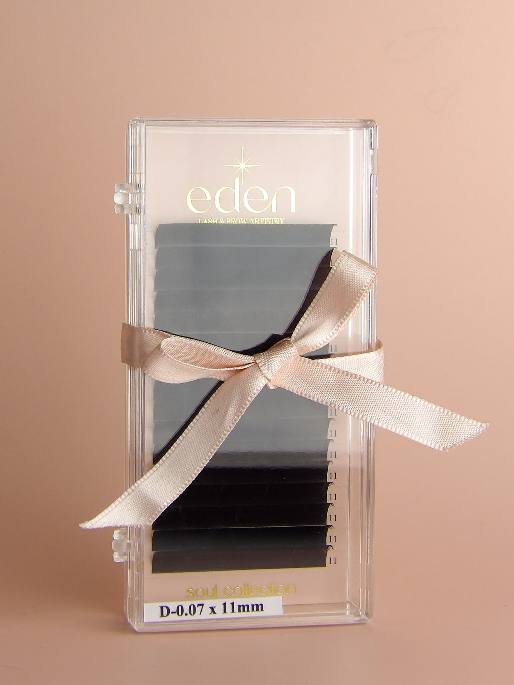 Eden lash extensions in a clear packaging with a beige ribbon on a beige background
