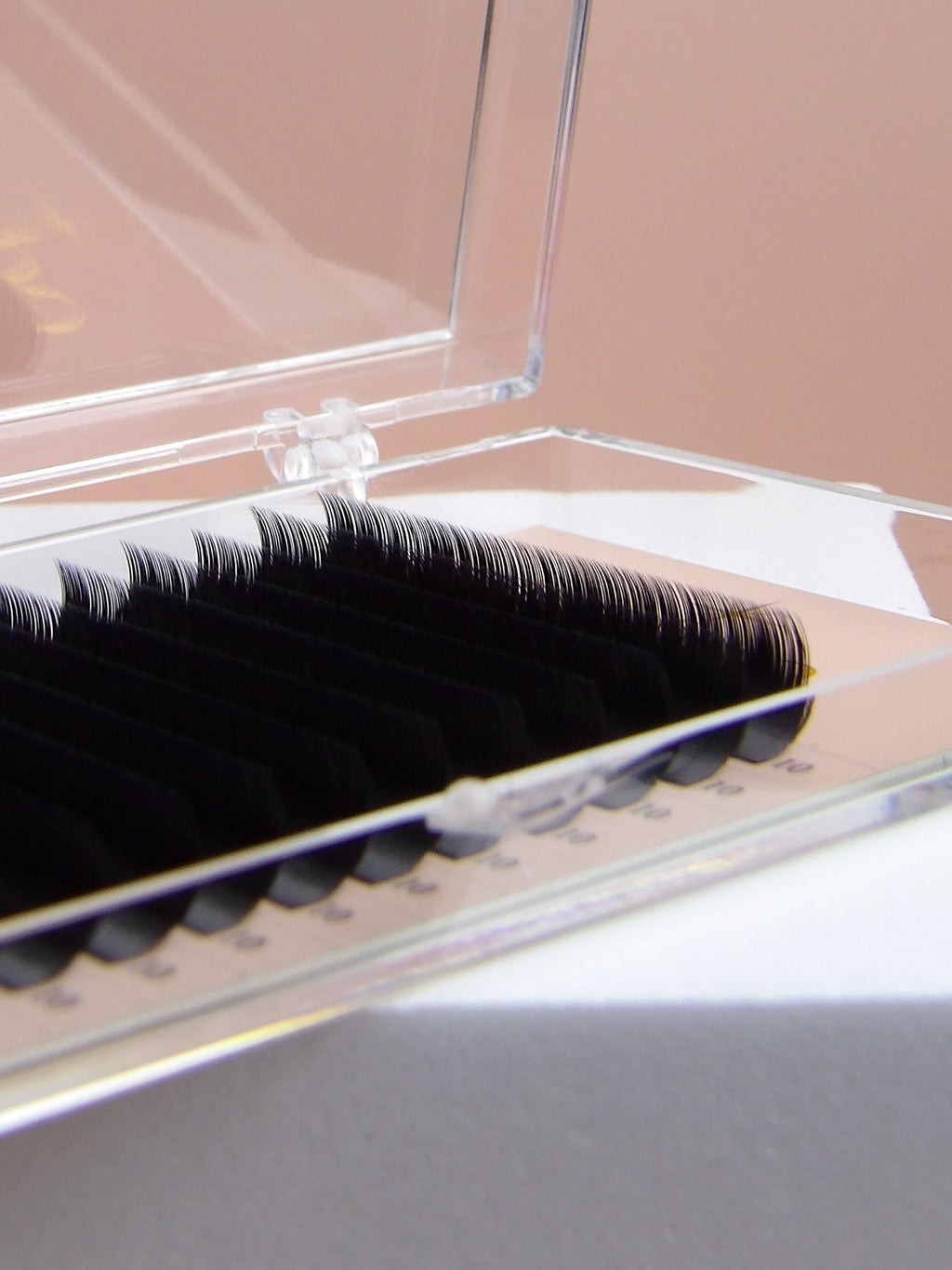 False eyelashes in an open clear case on a neutral background