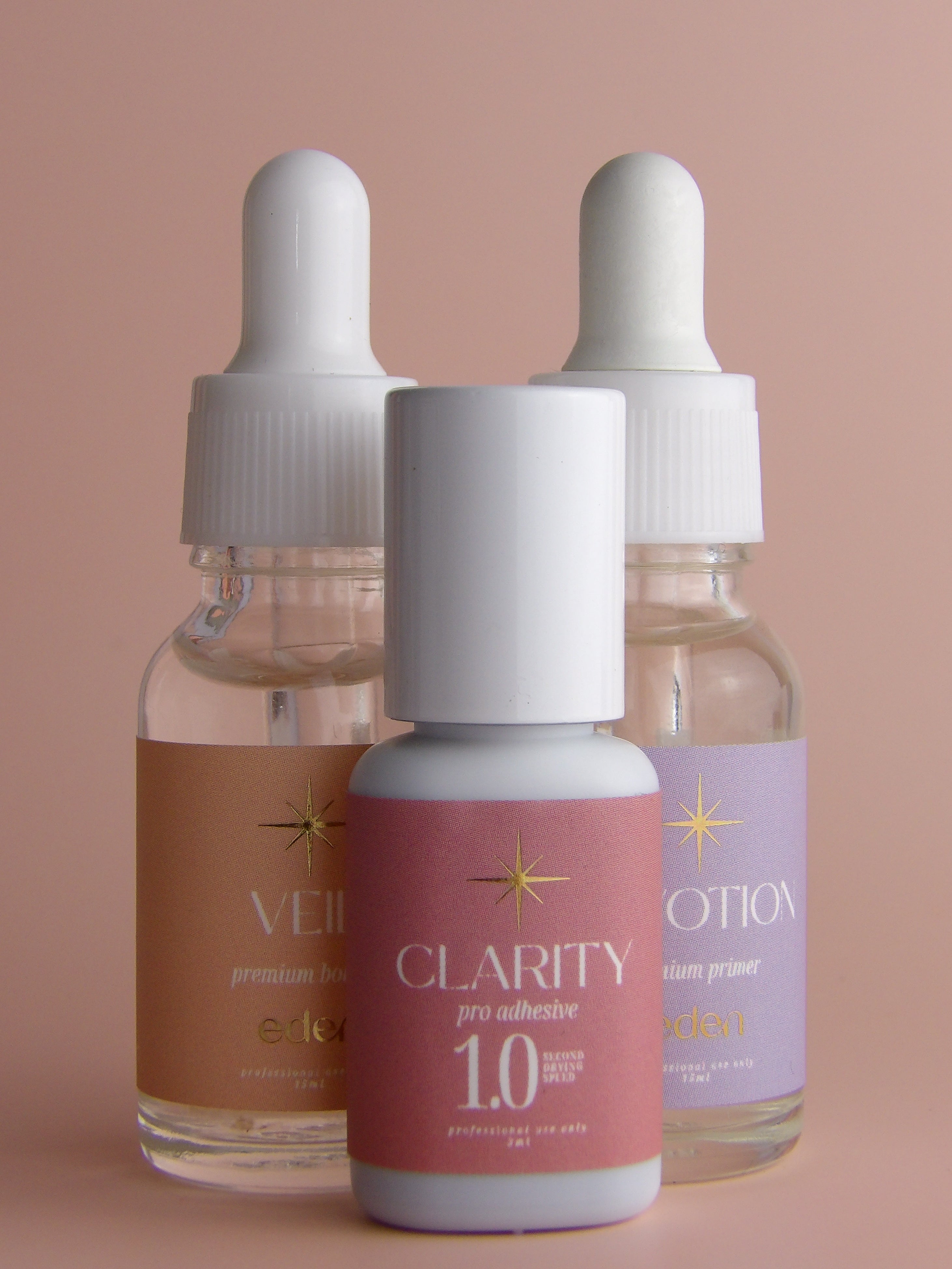 Three dropper bottles labeled 'Veil', 'Clarity', and 'devotion' on a beige background