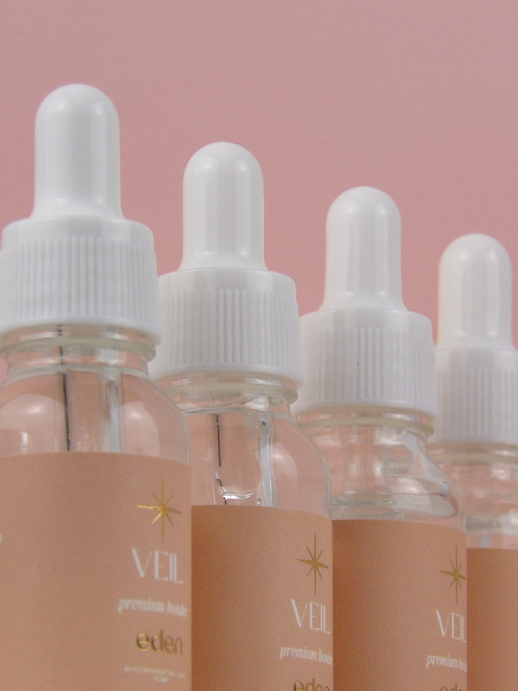 Bottles of Veil premium e-liquid on a pink background